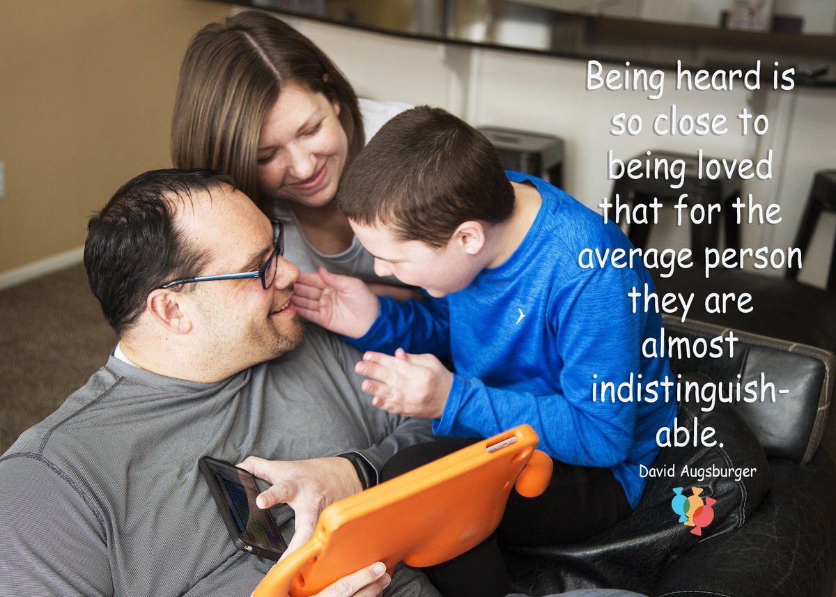 Two parents and a young boy in a blue shirt sit together smiling and holding an AAC device in an organge case.  Quote reads, "Being heard is so close to being loved that for the average person they are almost indistiguishable."